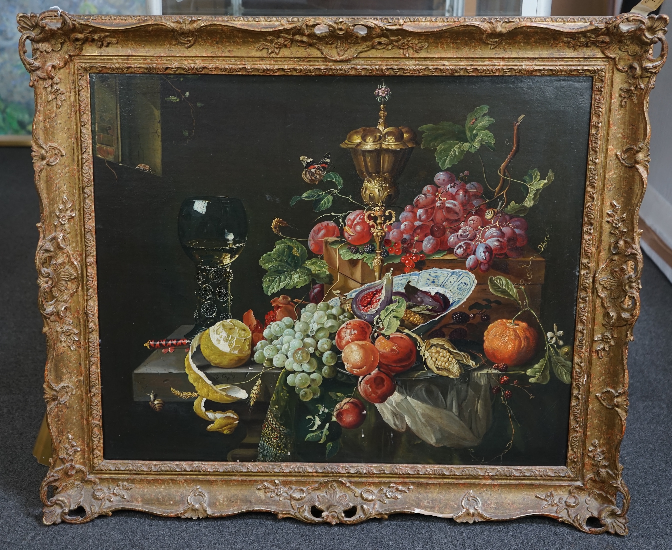 After Abraham Mignon (German, 1640-1679), 17th century style still life of fruit, a rummer and a gilt cup and cover upon a ledge, oil on canvas, 62 x 75cm